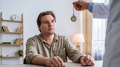 Мужчина смотрит на ручные часы в руке